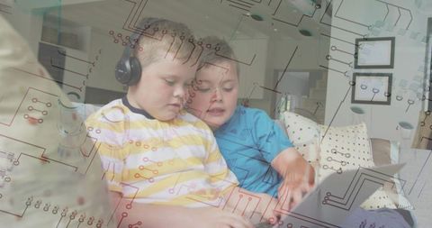 Brothers watching tablet with headphones and circuit overlay illustrating kids technology