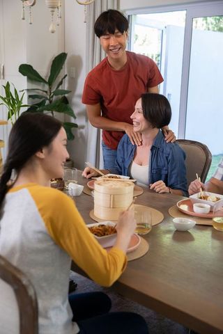 Happy Group of Friends Enjoying Meal at Home with Bamboo Steamer