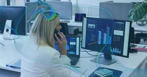 Businesswoman Analyzing Financial Data on Screens in Modern Office