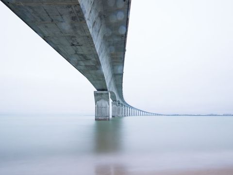Majestic view of long bridge over zen ocean waters
