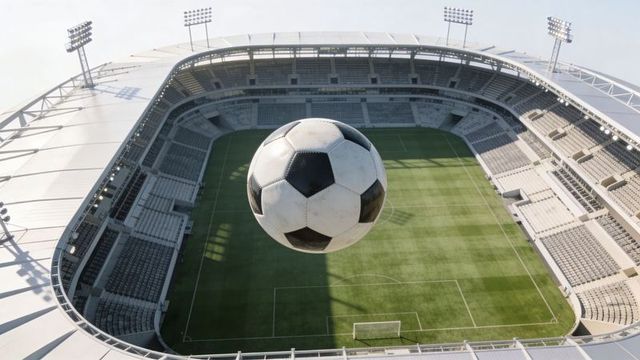 Scuffed soccer ball dominating aerial view of empty stadium pitch for sports promotion
