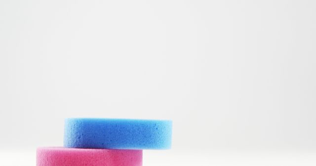 Vividly colored household cleaning sponges, with one blue sponge and one pink sponge neatly stacked on a clean, white background. This image suggests themes of cleanliness and domestic chores and is perfect for promoting cleaning products, household tips, and related blogs. Ideal for advertisements in the cleaning industry, social media content, and instructional guides.