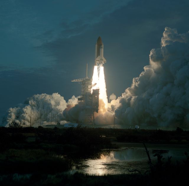 Space Shuttle Columbia launching at dawn from Kennedy Space Center for the STS-32 mission on January 9, 1990. The image shows the shuttle with smoke and flames as it ascends into the sky. This historical event is significant for space exploration, highlighting NASA's advancement and commitment to space science. Useful for articles on space history, educational materials on space missions, and promotions for science and technology museums.