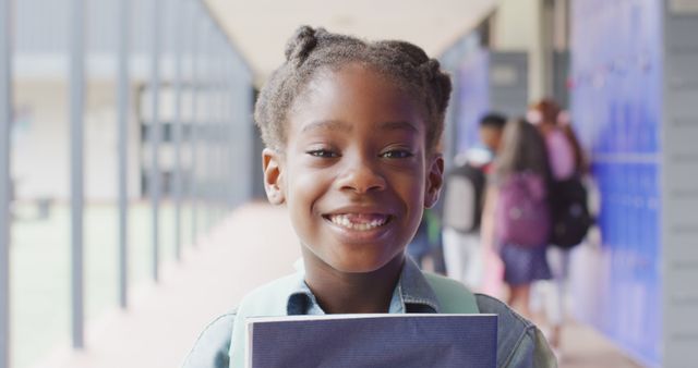 Smiling Girl Holding Book in School Hallway - Download Free Stock Images Pikwizard.com