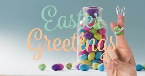 Hand holding finger bunny, jar filled with pastel speckled eggs, easter greetings lettering