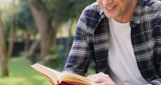 Man reading book outdoor in garden, happy and smiling - Download Free Stock Images Pikwizard.com