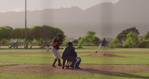 Baseball Player Swinging in Action on Sunlit Field
