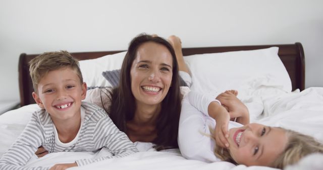 Mother and Children Smiling Together on Bed - Download Free Stock Images Pikwizard.com