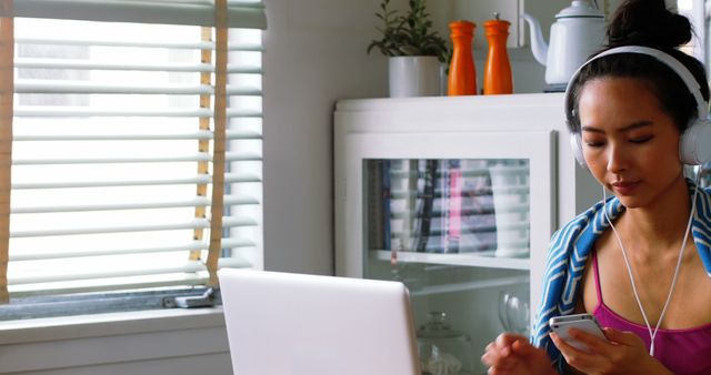 Woman Listening Music on Headphones While Using Smartphone at Home - Download Free Stock Images Pikwizard.com