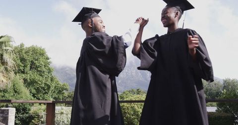 Graduates celebrating achievement in scenic outdoor ceremony