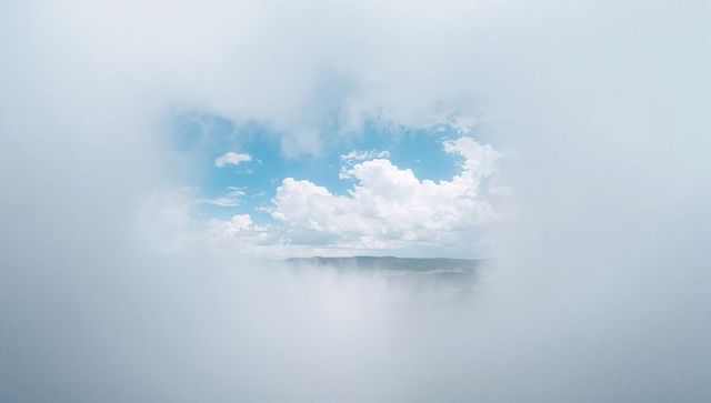 Blue Sky Emerging Through Blanket of Mist