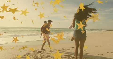 Family walking on sunny beach carrying children with gold star overlays celebrating summer