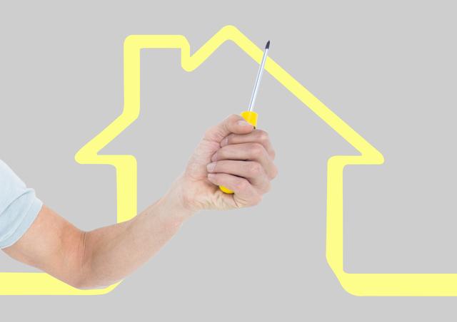 Digital composite of Hand with screwdriver with yellow house background