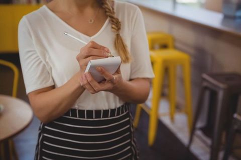 Female Server Taking Order in Casual Cafe Setting