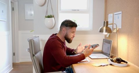 Remote Worker Engaged in Video Conference at Home Workspace
