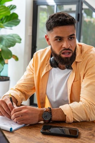 Focused Man Taking Notes in Modern Office Workspace