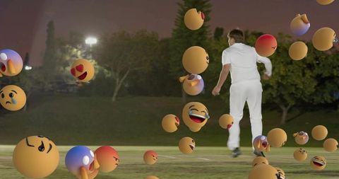 Night cricket bowler running through floating emoji orbs under floodlights