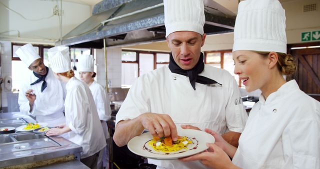 Chefs Collaborating in Commercial Kitchen Preparing Gourmet Dish - Download Free Stock Images Pikwizard.com