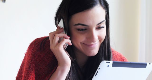 Smiling woman multitasking with tablet and phone at home - Download Free Stock Images Pikwizard.com