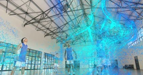 Basketball team standing on indoor court watching futuristic blue holographic swirl