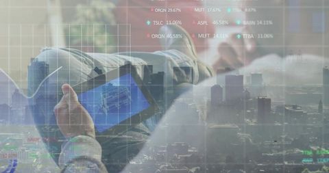Reclining Asian man holding tablet with blueprint overlay, city skyline and stock tickers