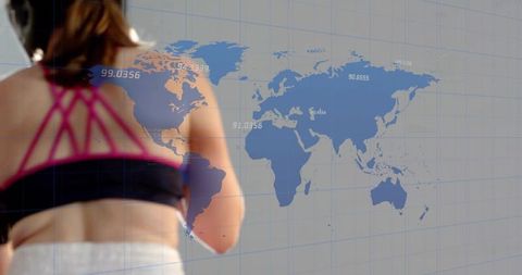 Female athlete training with world map data overlay in studio gym for global fitness