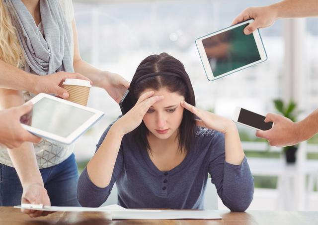 This image depicts a woman feeling stressed and overwhelmed in an office environment, surrounded by multiple electronic devices such as tablets and smartphones. Ideal for illustrating concepts related to workplace stress, multitasking, digital overload, and the impact of technology on mental health. Suitable for use in articles, blogs, presentations, and marketing materials focused on productivity, work-life balance, and professional challenges.