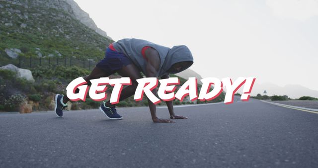 Athlete in hoodie and sneakers getting ready for run on rural road with text 'Get Ready!' overlay. Suitable for fitness advertisements, social media posts, motivational posters, and health promotions.