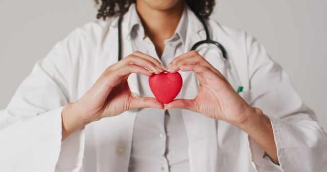 Image of biracial female doctor holding heart on white background - Download Free Stock Photos Pikwizard.com