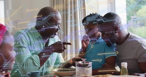 Grandfather pointing while teaching child at breakfast with technology circuit overlay