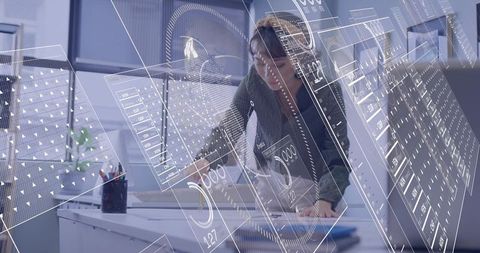Asian woman analyzing tablet with augmented reality dashboard overlays in modern office
