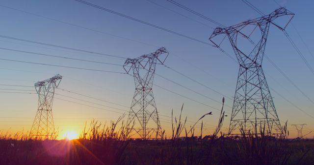 General view of electricity pylons over sun and blue sky. Electricity, energy, environment, landscape and transmission.