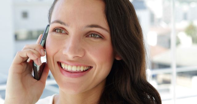 Smiling Woman Talking on Smartphone in Bright Office - Download Free Stock Images Pikwizard.com