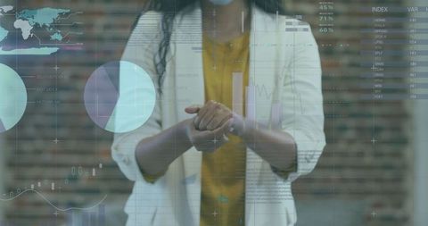 Businesswoman sanitizing hands with digital financial data overlay