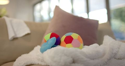 Vibrant patchwork balls and toy on plush blanket in cozy interior
