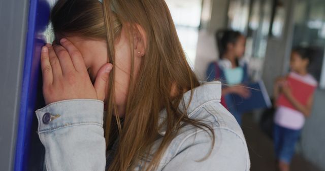 Image of sad caucasian girl crying by lockers in school corridor, copy space - Download Free Stock Photos Pikwizard.com
