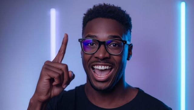 Enthusiastic man pointing up and smiling wearing glasses with neon purple and cyan studio lights