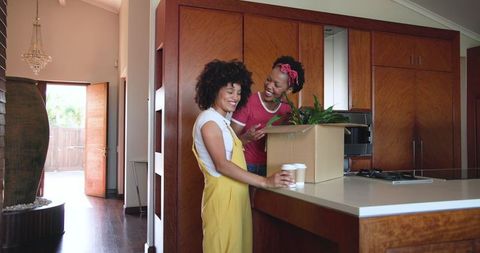 Diverse Female Couple Unpacking in Modern Kitchen