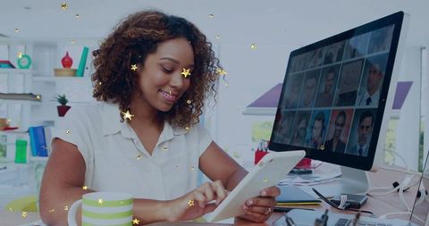 Smiling woman tapping tablet during video conference and remote collaboration in bright home office