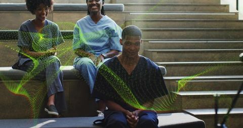 Nurses sitting on tiered steps with male nurse clasping hands, green hologram overlay