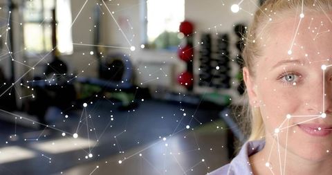 Woman facing camera in gym with network overlay conveying fitness tech and wellness