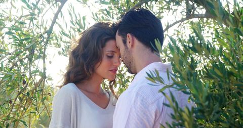 Romantic Couple Embracing in Sunlit Garden Filled with Greenery - Download Free Stock Images Pikwizard.com
