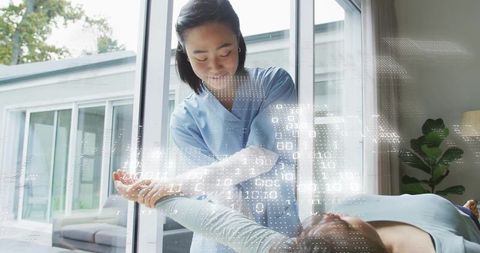 Nurse holding patient arm with digital binary overlay for telehealth rehab and care
