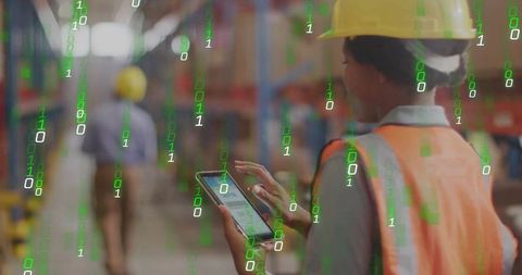 Warehouse worker using tablet for digital inventory with binary data overlay