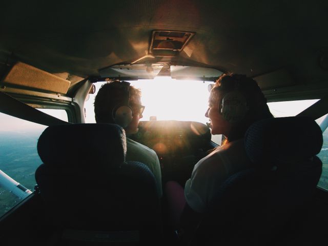 Couple seated in a small airplane cockpit enjoying a scenic flight during sunset. Perfect for travel advertisements, aviation-themed content, adventure promotions, and romantic getaways.
