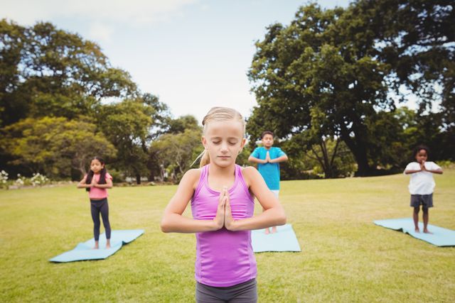 Close up view of girl doing yoga with friends in the park