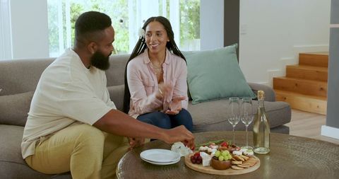 Couple Celebrating at Home with Wine and Cheese Platter
