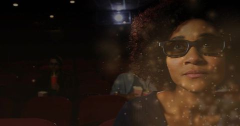 Watching woman wearing 3d glasses in dark cinema, absorbing film with projector flare and popcorn