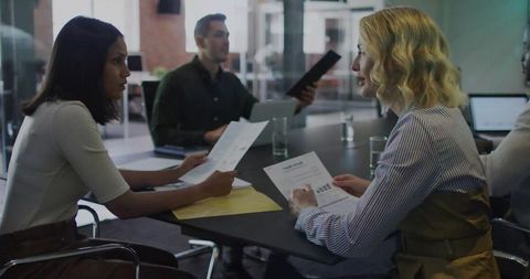 Team Collaboration with Printed Reports in Modern Office Meeting