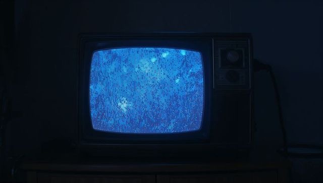 Vintage crt television with blue static in dimly lit room
